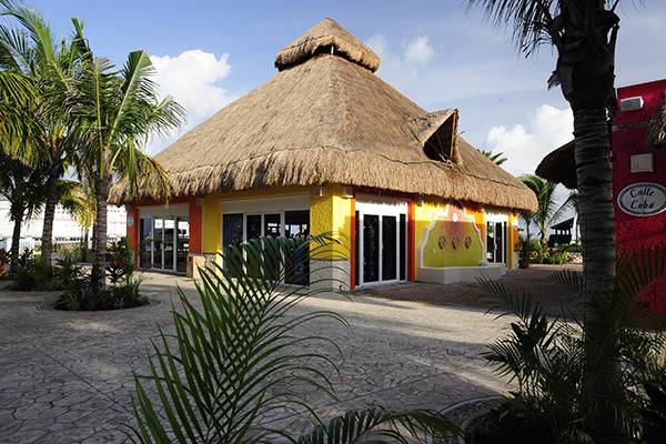 In Puerto Maya im Reiseziel Mexikanische Riviera steht ein gelbes Haus mit Strohdach.